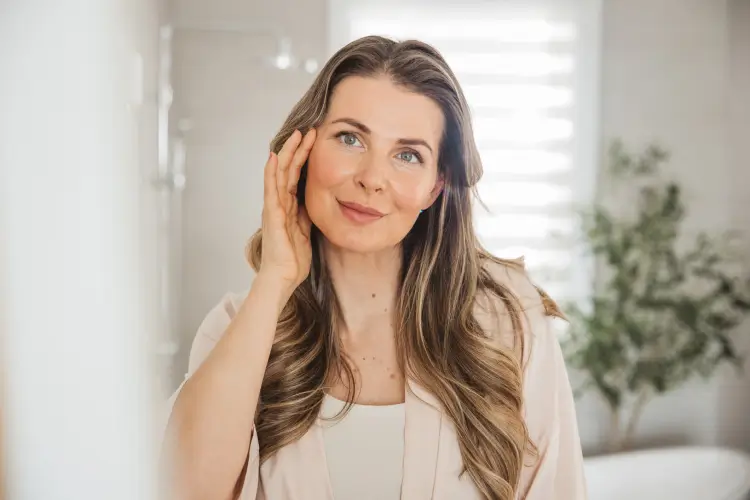 Considering Plastic Surgery in Foley? Choose Dr. Fedok: Woman touching cheek indoors